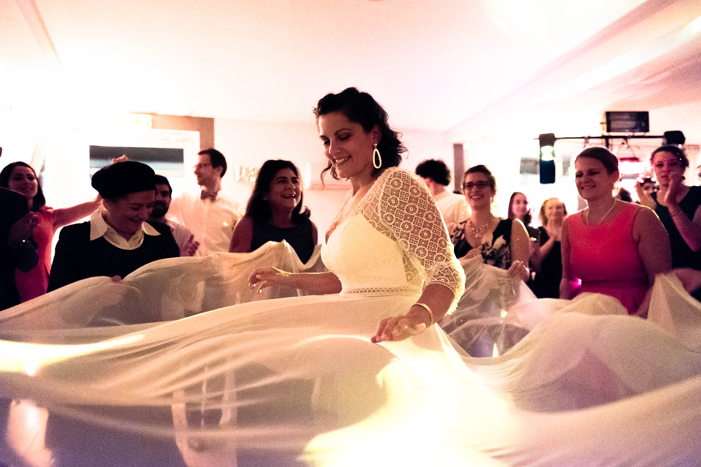 les femmes attrapent le voile de la robe de la mariee pour la faire danser comme le veut la coutume juive
